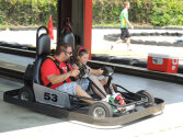 Two campers sitting in a go-kart.