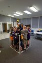 Group of campers and counselors standing inside large PVC pipe cube