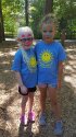 Two young campers in blue shirts smiling.
