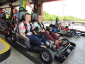 Two campers sitting in a go-kart.