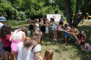 Groups holding PVC tubes together to play water relay