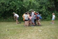 Group of campers and counselors walking through PVC pipe