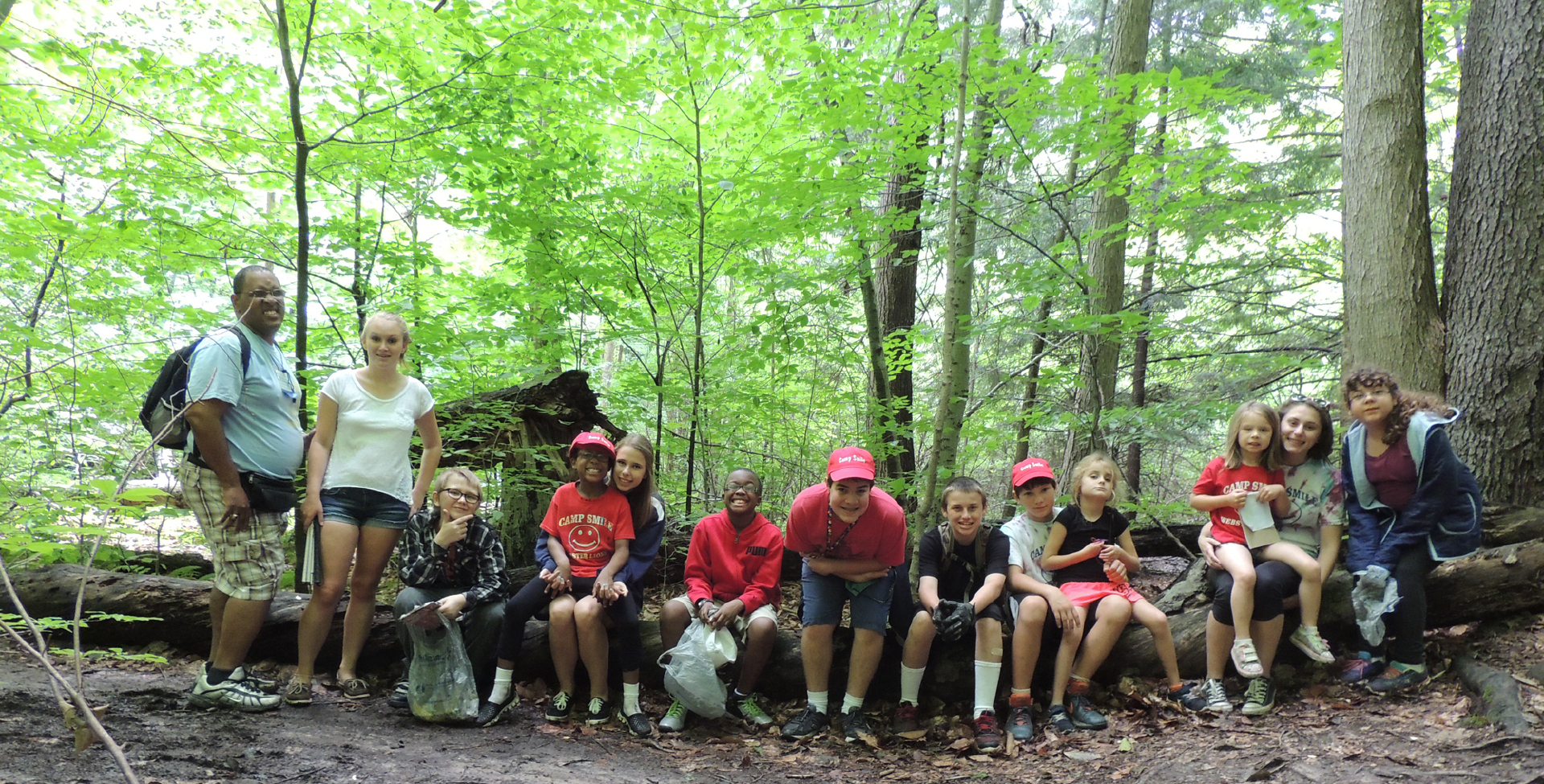 Group of campers sitting on a log.
