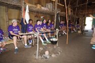 Campers & counselors sitting in a long house at Gonondagan