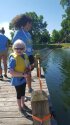 Young camper smiling as she fishes.